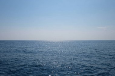Geniş mavi deniz ufku. Huzurlu okyanus yüzeyinde güneş ışığı yansıması. basitlik.