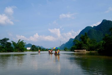 Huzurlu nehirde yüzen birkaç bambu salları. Perspektif yeşil dağlar. Mavi güneşli gökyüzü ve beyaz bulutlar. Yangshuo Guilin Çin 'de. Karst toprak formu