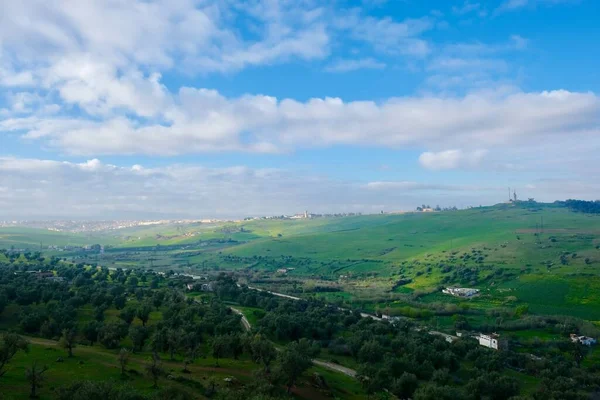 aerial view of green valley with trees and grassland. Under sunny blue sky white clouds. In Fez Morocco North Africa. Wide angle
