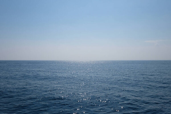 wide deep blue sea horizon. peaceful ocean surface with sunlight reflection. simplicity.
