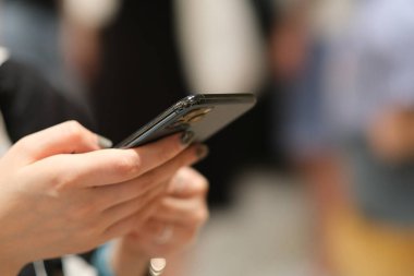 Akıllı telefon kullanarak kadının ellerini kapat. bokeh arkaplanı