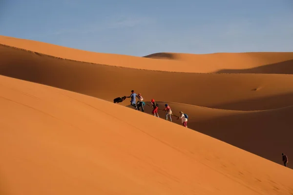 Flere Turister Klatrer Sanddynene Sahara Dagslys Nær Landsbyen Merzouga Marokko – stockfoto