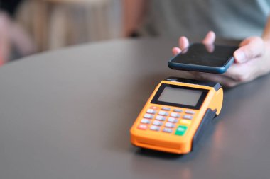 Yakın plan akıllı telefonu Po Terminali 'nin üzerinde masanın üzerinde tutuyor. Bulanık arkaplan