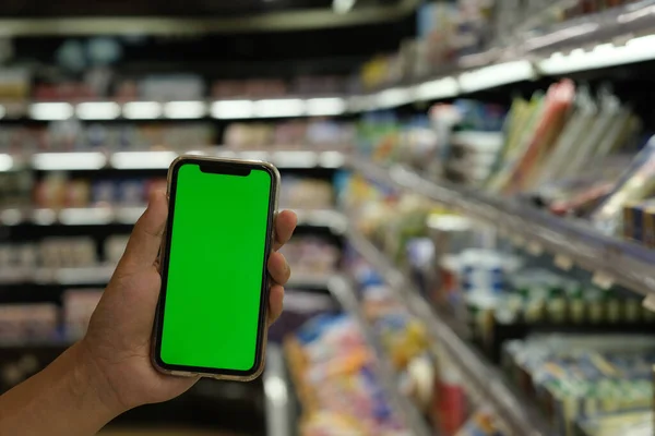 Fechar Mão Mostrando Telefone Inteligente Tela Verde Supermercado — Fotografia de Stock