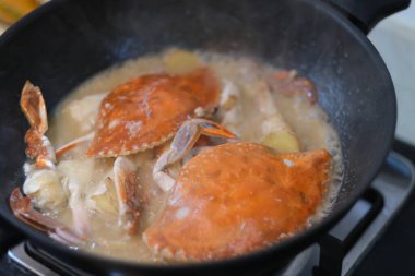 Yüzme yengecini siyah tencerede pişirin. Asya mutfağı