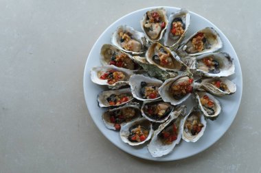 Beyaz masadaki baharatlı ızgara istiridye tabağının üst görüntüsü..