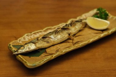 Ahşap masadaki limonlu saury 'yi kapatın. Geleneksel Japon mutfağı