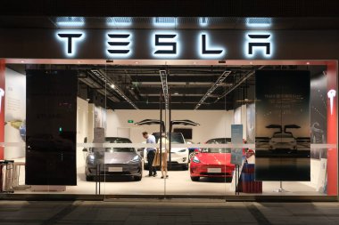 Şangay / Çin-Eylül 2020: geceleri Tesla mağazasının ön cephesi. Tesla perakende mağazasındaki müşteriler elektrikli araba seçiyorlar