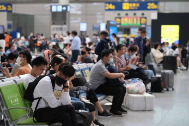 Şangay / Çin-Ekim 2020: Şangay Hongqiao Tren İstasyonu 'nda oturan yolcular, koronavirüsü önlemek için maske takıyorlar.. 