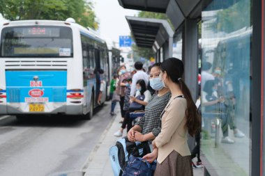 Wuhan / China-Ekim 2020: Yüz maskesi takan vatandaşlar otobüs durağında bekliyor