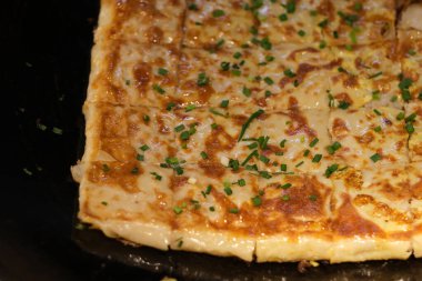 Siyah tencerede tofu derisi (Doupi). Wuhan 'da geleneksel yemekler, Hubei, Çin. Kahvaltılık atıştırmalıklar çoğunlukla fasulye, un, yumurta ve yapışkan pirinçten yapılır.