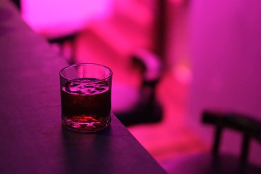 Koyu bar tezgahında bir bardak kokteyl.