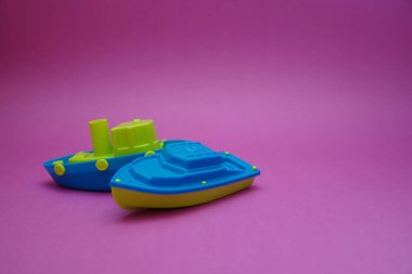 Pembe arka planda iki oyuncak tekne.