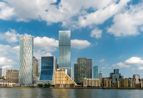 Financial district buildings in Canary Wharf area of London in. a daytime against cloudy blue sky