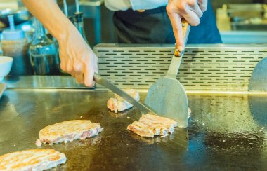 Aşçı ahtapotu metalik tabakta döndürür