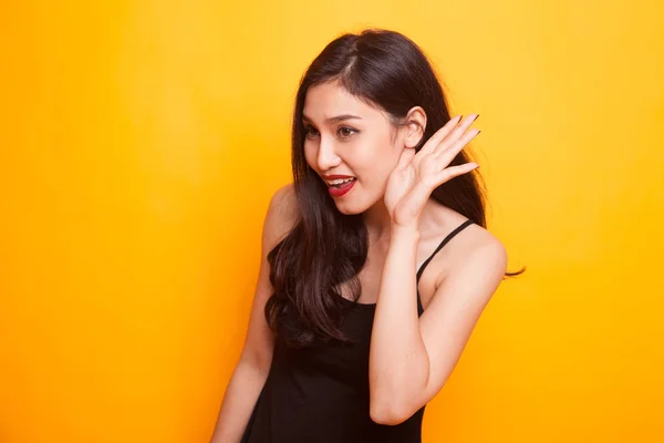 Sleepy young Asian woman yawn on yellow background