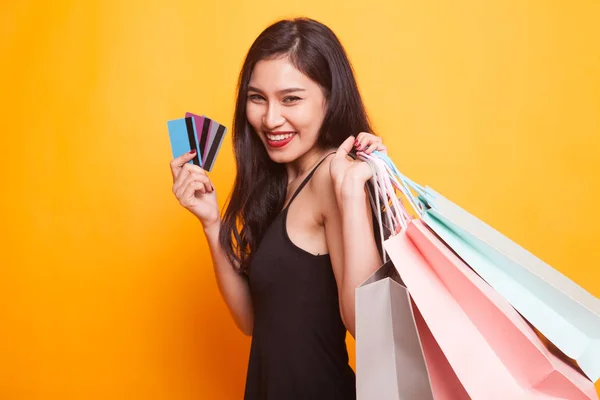 ショッピング バッグと黄色の背景の空白のカードを持つ若いアジア女性 — ストック写真