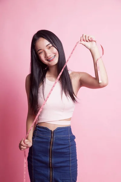 粉红色背景测量磁带的年轻亚洲妇女 — 图库照片
