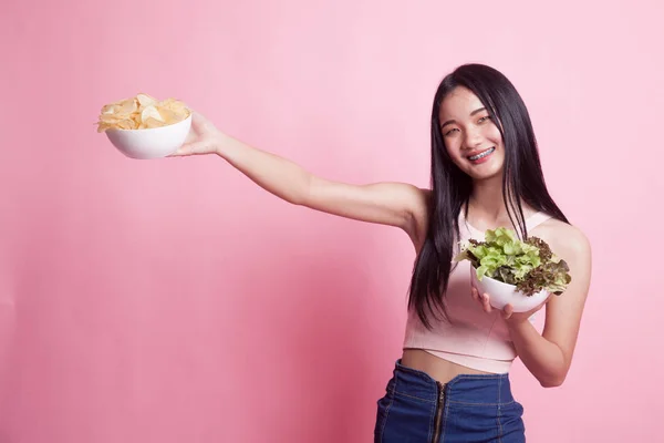 年轻的亚洲女人 有薯片和粉色背景的沙拉 — 图库照片