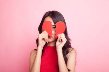 Pembe arka planda kalbi kırık güzel bir Asyalı kadın.