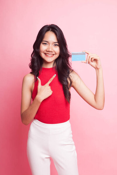 Young Asian woman point to a blank card on pink background