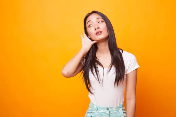 Bela Jovem Ásia Mulher Ouvir Algo Brilhante Amarelo Fundo — Fotografia de Stock