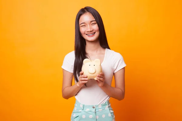 Jovem Mulher Asiática Com Banco Moedas Porco Fundo Amarelo Brilhante — Fotografia de Stock