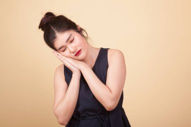 Bej arka planda uyku jesti olan güzel bir Asyalı kadın.