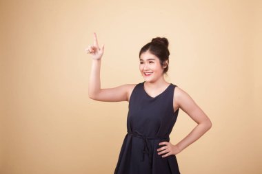 Asyalı kadın bej arka planda parmaklarıyla ekrana dokunuyor.