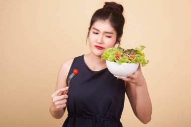 Asyalı kadın bej arka planda salatadan nefret eder