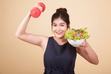 Kol halkaları ve bej arka planda salatası olan sağlıklı Asyalı kadın.