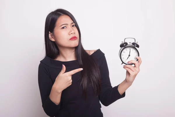 愤怒的年轻亚洲女人指向一个白色背景上的时钟 — 图库照片