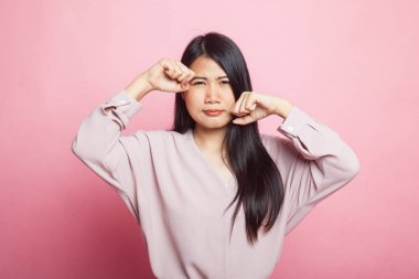 Genç Asyalı kadın üzgün ve pembe arka planda ağlıyor