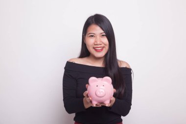 Beyaz zemin üzerinde bir domuz para banka ile genç Asyalı kadın