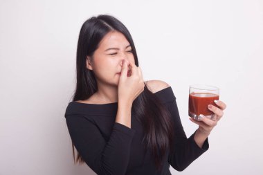 Genç Asyalı kadın nefret domates suyu beyaz arka plan üzerinde