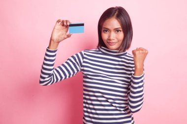 Pembe arka planda boş kartı olan genç Asyalı kadın yumruk pompası.