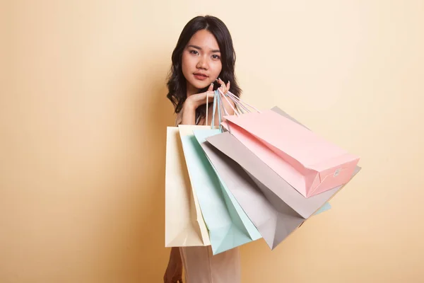 若いですアジアの女性幸せでショッピングバッグ上ベージュ背景 — ストック写真