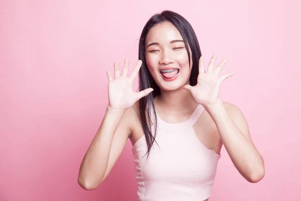 ピンクの背景に彼女の舌を付着若いアジア女性 — ストック写真