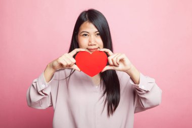 Pembe arka planda kırmızı kalpli Asyalı kadın.