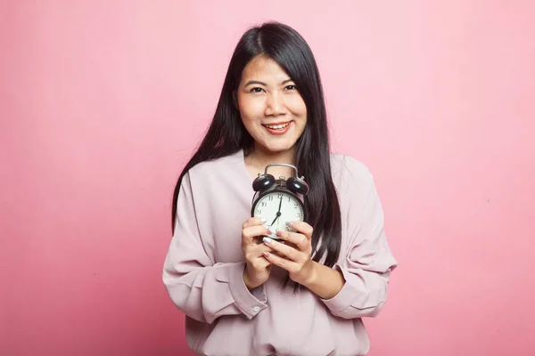Genç Asyalı Kadın Pembe Arka Planda Saati Olan Gülümsüyor — Stok fotoğraf
