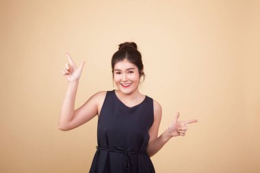 Bej arka planda iki eli olan Asyalı genç bir kadın.