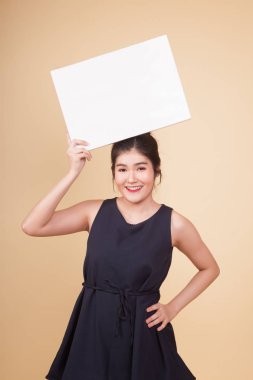 Bej arka planda beyaz boş işareti olan genç Asyalı kadın.