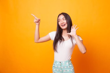 Boş yer üstünde parlak sarı arka plana noktasına heyecanlı Asyalı kadın