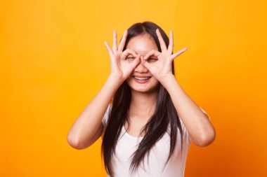 Asyalı kadın yapmak komik Çift Ok işareti olarak parlak sarı zemin üzerine gözlük