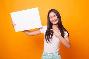 Parlak sarı zemin üzerine boş işaret noktasına Genç Asyalı kadın