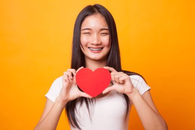 Parlak sarı zemin üzerine kırmızı kalpli Asyalı kadın