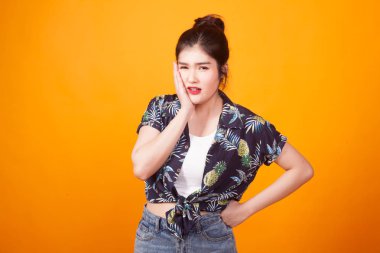 Genç Asyalı kadın diş ağrısı sarı arka plan tropikal forması var