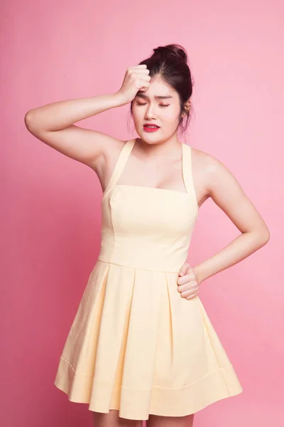 Young Asian woman got sick and  headache on pink background