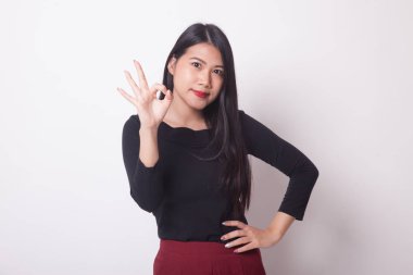 Genç Asyalı kadın gösteri Tamam beyaz arka plan üzerinde oturum