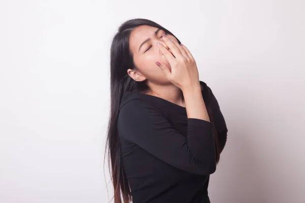 Sleepy young Asian woman yawn on white background